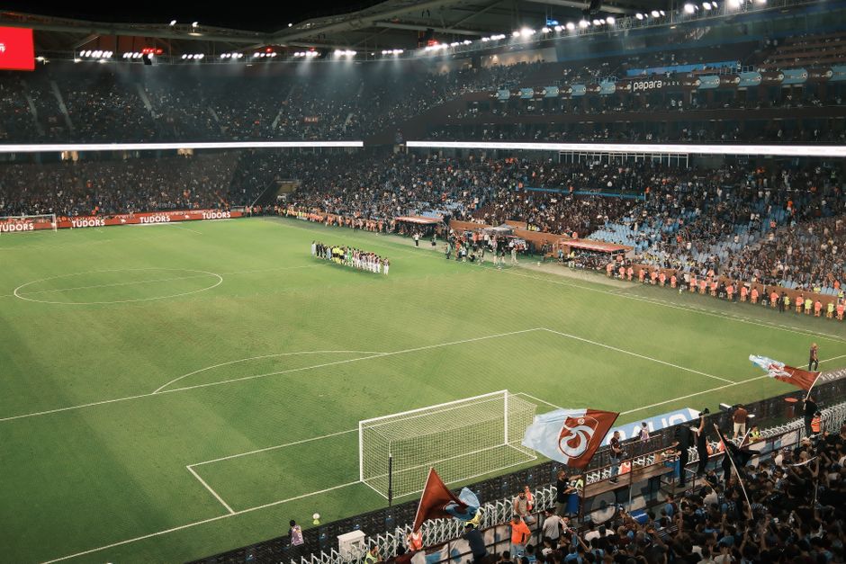 Packed stadium during an exciting night football match with vibrant crowd and field view.