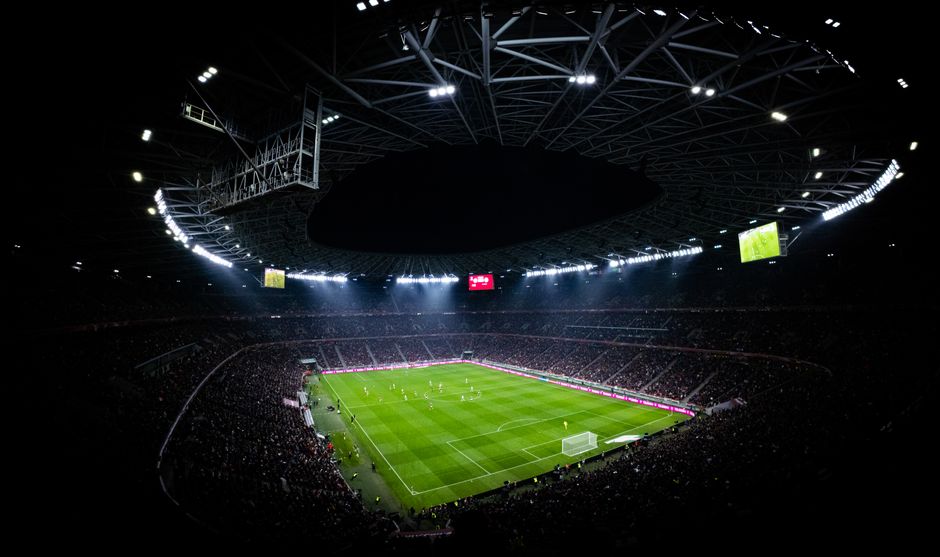 Aerial view of a night football match in Budapest. Illuminated stadium full of fans adds dramatic atmosphere.