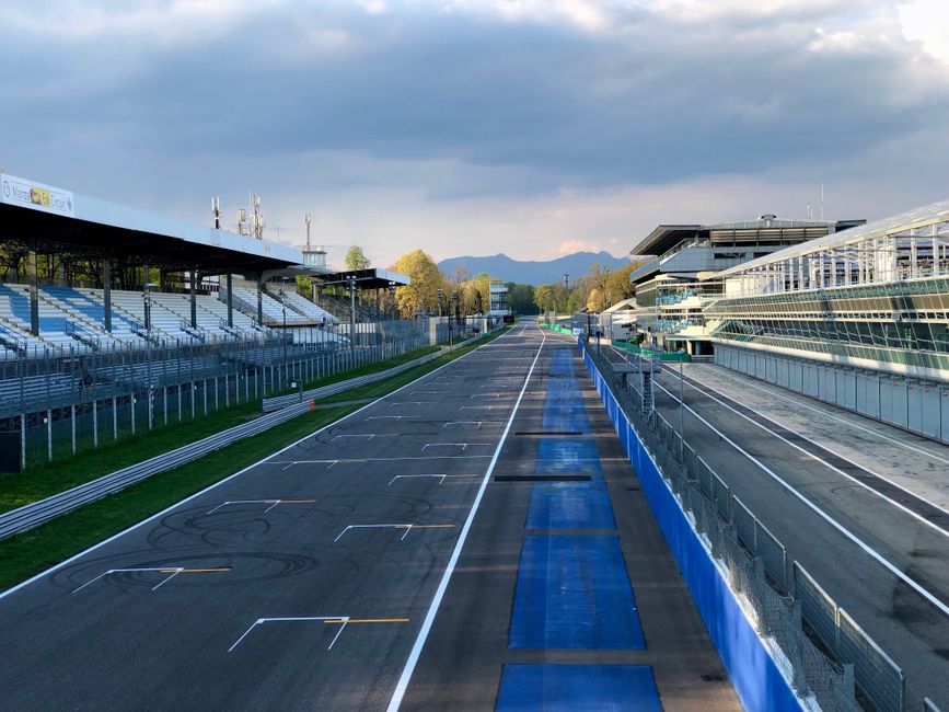 The empty pit straight at Monza Circuit in Italy, captured in serene afternoon light.